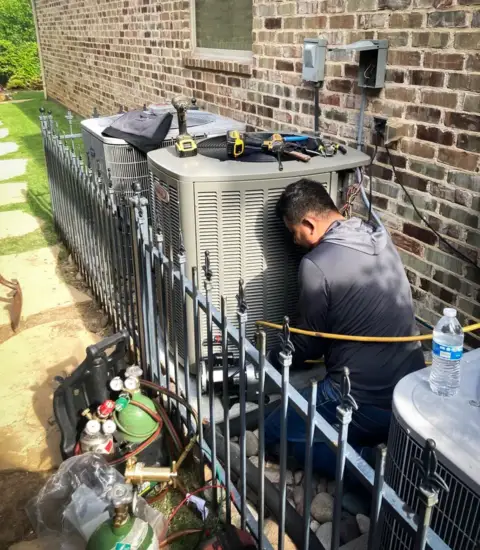 An HPH Services crew member is working on this customer's air conditioner.